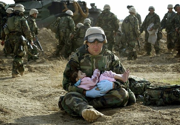 „Reuters“/„Scanpix“ nuotr./JAV karys laiko irakiečių vaiką.