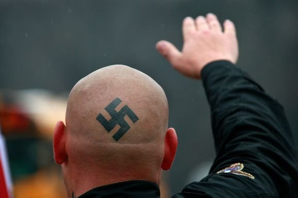 AFP/„Scanpix“ nuotr./Radikaliai nusiteikę protestuotojai net ir galvas pasipuošė svastikomis.