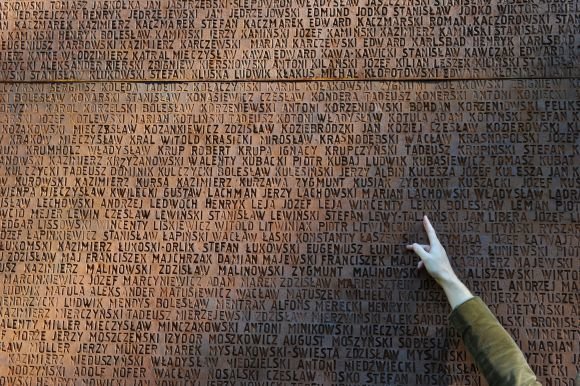 AFP/„Scanpix“ nuotr./Katynėje nužudytųjų pavardės iškaltos ant memorialinės sienos.