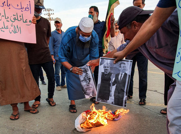 AFP/„Scanpix“ nuotr./Protestuotojai Libijoje degina Emmanuelio Macrono nuotrauką