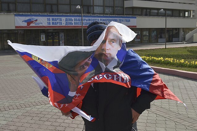 AP nuotr./Sevastopolio gyventojas su vėliava per V.Putino vizitą Kryme