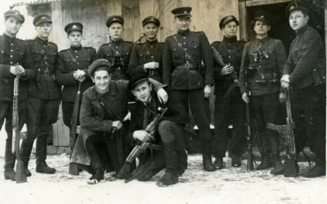 Genocido aukų muziejaus / informnapalm.org nuotr./Juozas Lukša-Daumantas ir Kazimieras Pyplys-Audronis (pirmoje eilėje priklaupę) prieš žygį į Vakarus atsisveikina su Tauro apygardos partizanais. 1947 m. gruodžio 16 d. 