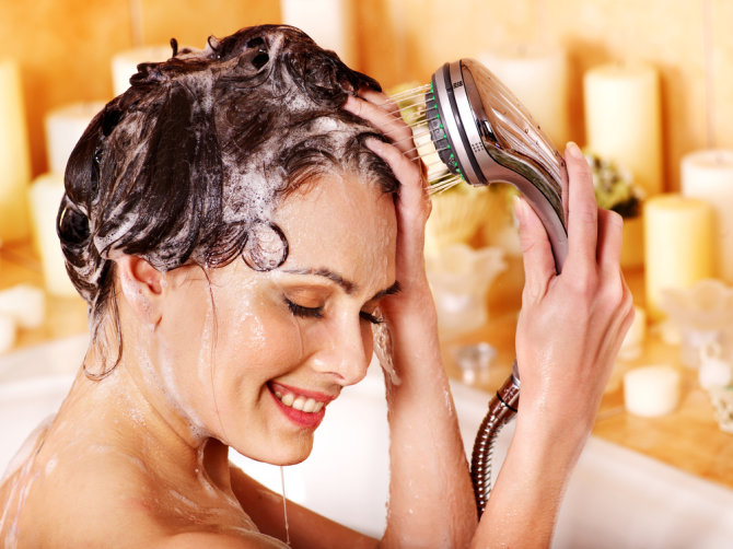 Shutterstock nuotr./Moteris plaunasi plaukus