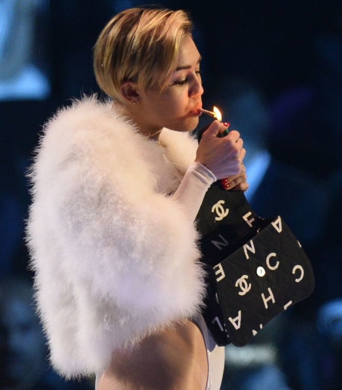 „Reuters“/„Scanpix“ nuotr./Miley Cyrus užsirūkė ant scenos