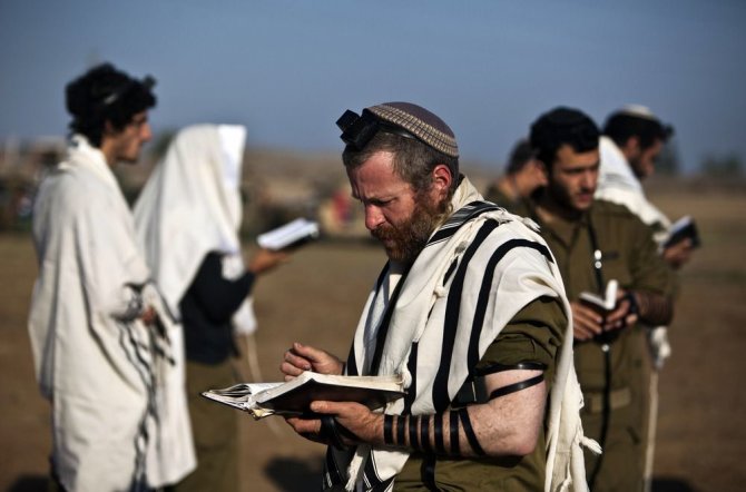 „Reuters“/„Scanpix“ nuotr./Izraelio kariai meldžaisi netoli sienos su Gazos Ruožu.