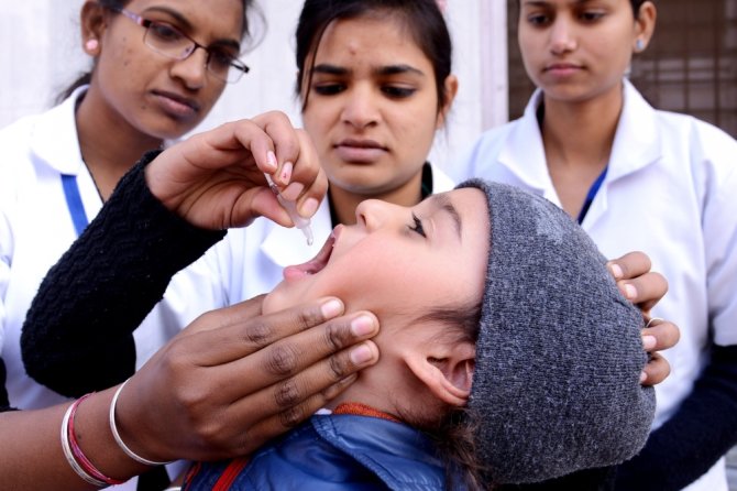 AFP/„Scanpix“ nuotr./Vaikas Indijoje gauna vakciną nuo poliomielito