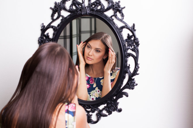 Shutterstock nuotr./Moteris žiūri į veidrodį