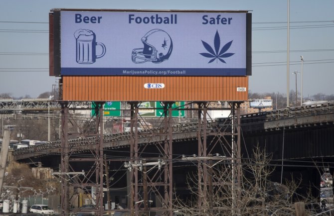 „Reuters“/„Scanpix“ nuotr./Reklaminis stendas JAV, teigiantis, kad marihuana sveikatai kelia mažesnį pavojų nei alkoholis ar amerikietiškas futbolas. reuters