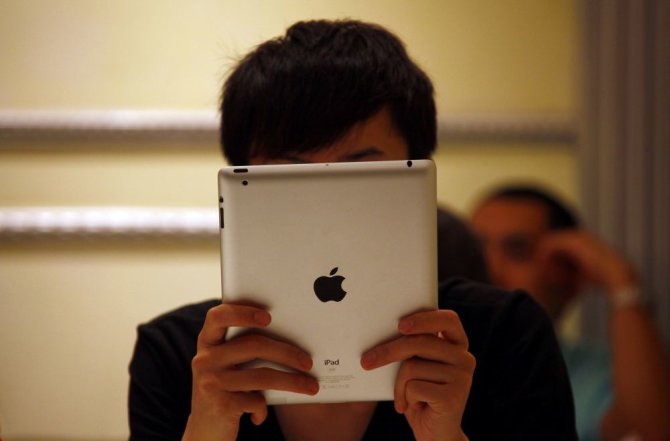 „Reuters“/„Scanpix“ nuotr./Žmogus laiko planšetinį kompiuterį „iPad“.
