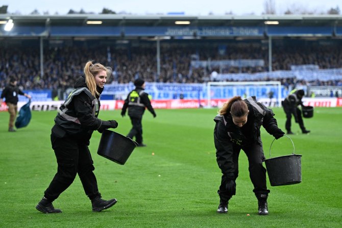 „Scanpix“ nuotr./Vokietijos futbolo sirgaliai protestuodami mėto į aikštę teniso kamuoliukus