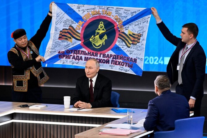 Vladimiras Putinas ir Ramiojo vandenyno laivyno 155-osios jūrų pėstininkų brigados vėliava / AFP