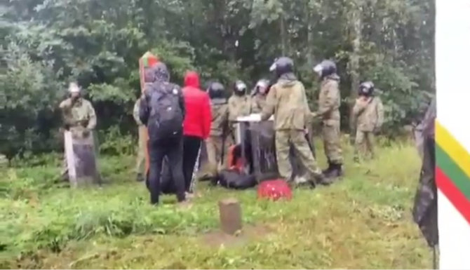Vaizdo įrašo STOP kadras/Baltarusijos pareigūnai su skydais blokuoja migrantų grąžinimą