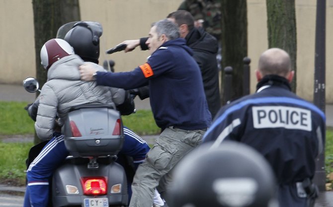 „Reuters“/„Scanpix“ nuotr./Paryžiuje netoli parduotuvės, kurioje ginkluotas vyras laiko įkaitus, sulaikyti du motoroleriu važiavę vyrai.