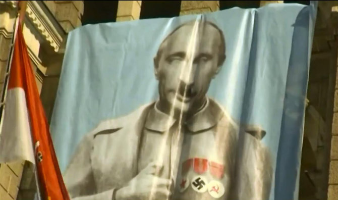 „Youtube.com/Double Power“ stop kadras/Vladimiro Putino didžiulė karikatūra ant Libereco miesto rotušės