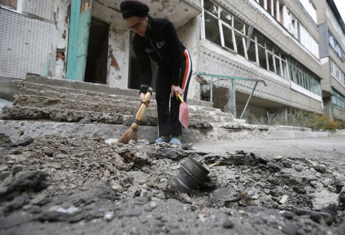 „Reuters“/„Scanpix“ nuotr./Delbacevo mieste prie daugiabučio laiptinės nukrito artilerijos sviedinys.