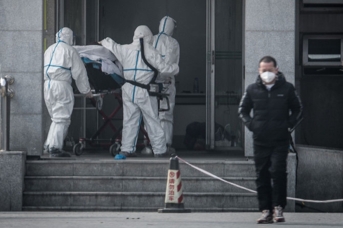 AFP/„Scanpix“ nuotr./Į ligoninę Kinijoje pristatomas infekuotas pacientas.