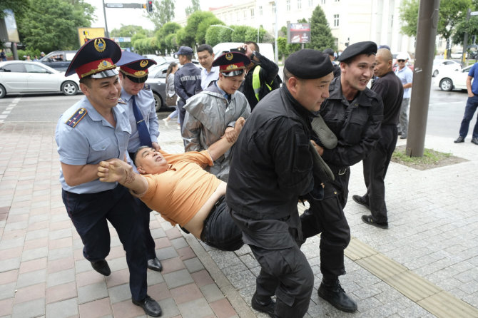 „Scanpix“/AP nuotr./Policija sulaiko protestuotoją Kazachstane