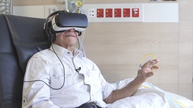 Pacientai naudojasi virtualios realybės akiniais.