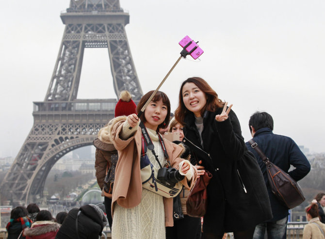 123rf.com nuotr./Turistės darosi asmenukę Paryžiuje prie Eifelio bokšto