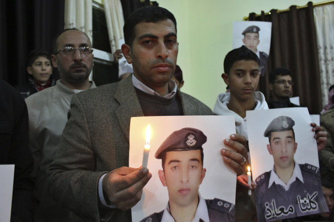 „Reuters“/„Scanpix“ nuotr./Jordanijos piloto Muazo al Kasasbecho (Muath al-Kasaesbeh) portretą laiko jo brolis