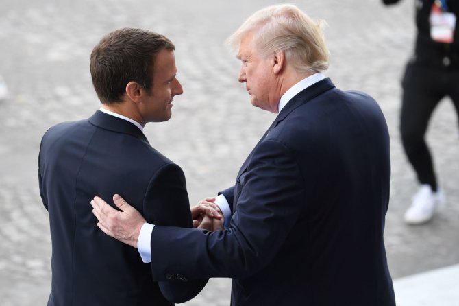 AFP/„Scanpix“ nuotr./Emmanuelis Macronas ir Donaldas Trumpas dar kartą apsikeitė ilgais rankų paspaudimais