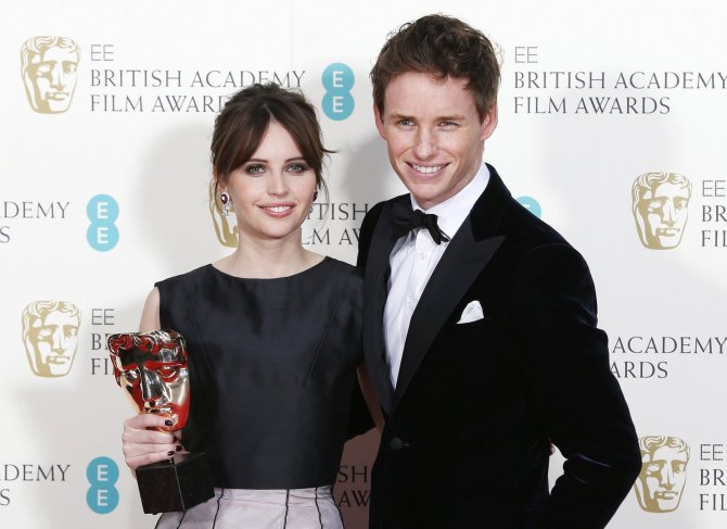 „Reuters“/„Scanpix“ nuotr./Felicity Jones ir Eddie Redmayne'as atsiėmė apdovanojimą už geriausią britų filmą „Visko teorija“