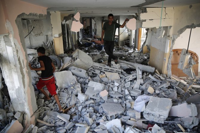 „Reuters“/„Scanpix“ nuotr./Į sugriuvusius namus sugrįže palestiniečiai ieško savo daiktų