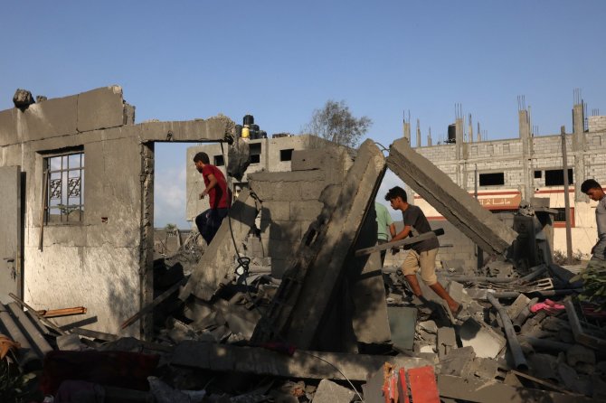 AFP/„Scanpix“ nuotr./Palestiniečiai tarp griuvėsių Rafoje, pietinėje Gazos Ruožo dalyje