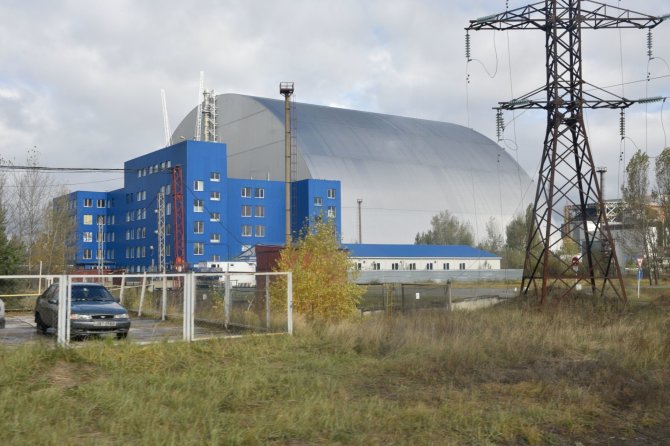 „Sputnik“/„Scanpix“ nuotr./Černobylyje naujas milžiniškas gaubtas pradėtas stumti ant branduolinio reaktoriaus