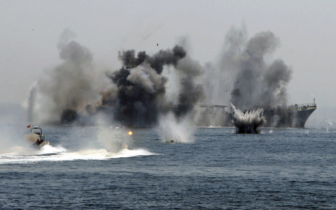 „Reuters“/„Scanpix“ nuotr./Irano karo laivas ir greitaeigiai kateriai dalyvauja Persijos įlankoje ir Ormūzo sąsiauryje vykstančiose karinėse jūrų pratybose/Asociatyvinė nuotr.