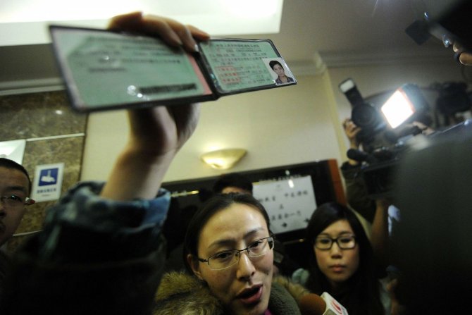 „Reuters“/„Scanpix“ nuotr./Moteris rodo pradingusio lėktuvo keleivio vairuotojo pažymėjimą