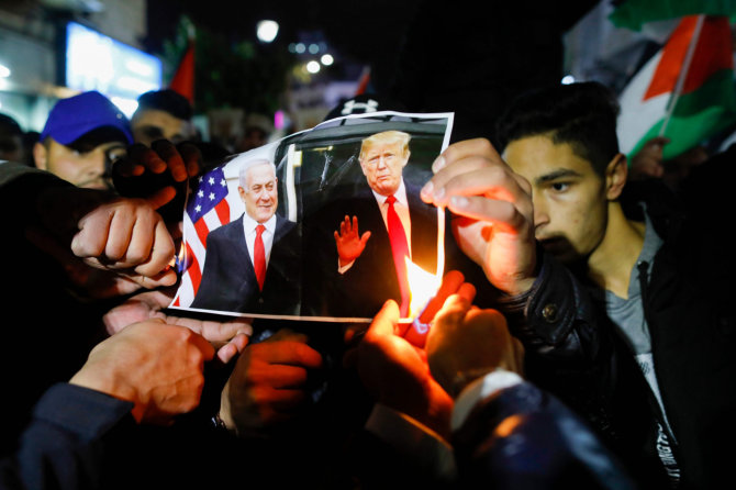 AFP/„Scanpix“ nuotr./Ramaloje protestuojantys palestiniečiai degina D.Trumpo ir B.Netanyahu nuotrauką.