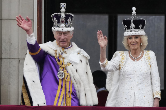 „Scanpix“/AP nuotr./Karūnuotasis karalius Karolis III ir karalienė Camilla iš Bekingemo rūmų balkono sveikina tautą