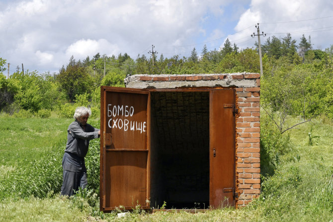 „AP“/„Scanpix“/Vietinė Donecko regiono gyventoja prie įėjimo į slėptuvę nuo bombų