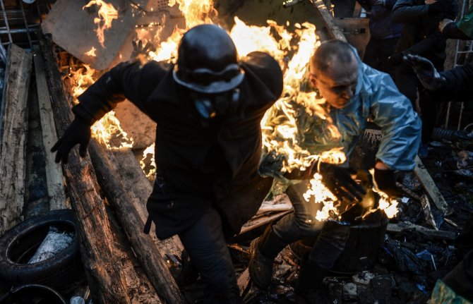 AFP/„Scanpix“ nuotr./Kijeve protestuotojai bėga nuo ugnies