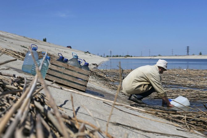 „Reuters“/„Scanpix“ nuotr./Kryme vyras semia vandenį.