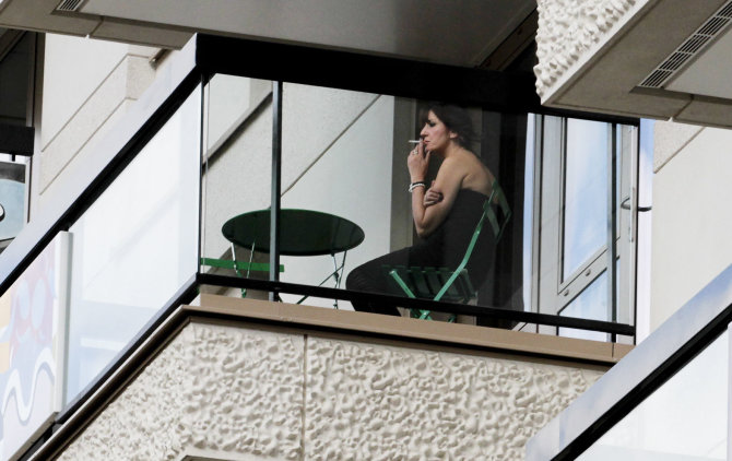 „Reuters“/„Scanpix“ nuotr./Rūkanti moteris balkone