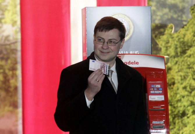 „Reuters“/„Scanpix“ nuotr./Valdis Dombrovskis su 10 eurų banknotu