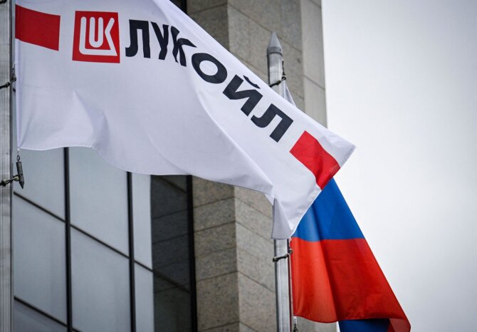 Rusijos vėliava šalia „Lukoil“ logotipo / ALEXANDER NEMENOV / AFP