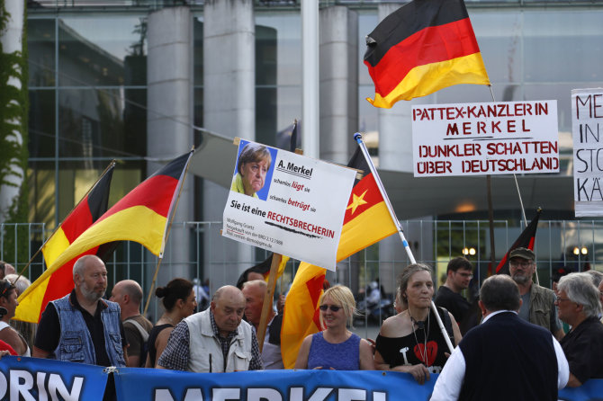 „Reuters“/„Scanpix“ nuotr./AfD aktyvistai protestuoja prieš Vokietijos vyriausybės migracijos politiką.