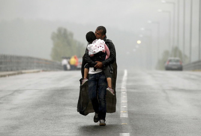 „Reuters“/„Scanpix“ nuotr./Pabėgėlis iš Sirijos su vaiku Makedonijoje