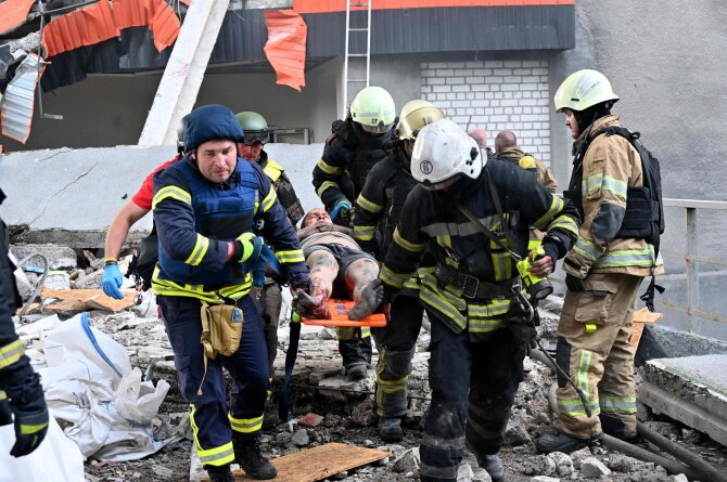 AFP/„Scanpix“ nuotr./Gelbėtojai Charkive