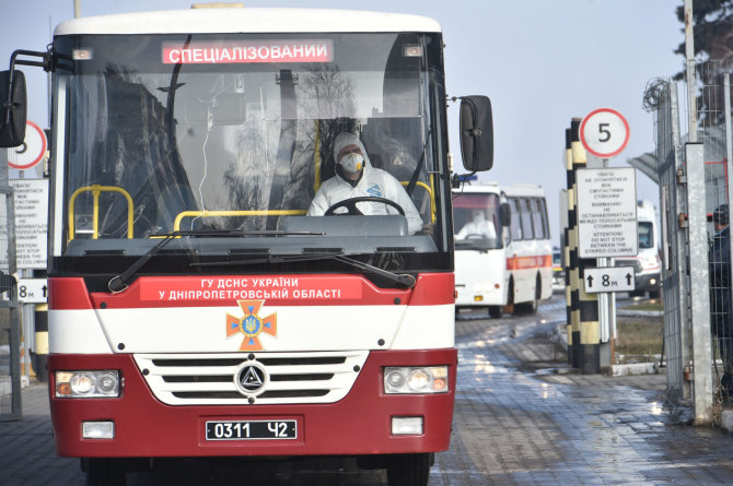 AFP/„Scanpix“ nuotr./Autobusas, vežantis iš Kinijos evakuotus ukrainiečius