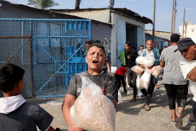 AFP/„Scanpix“ nuotr./Gazos Ruože dalijama humanitarinė pagalba