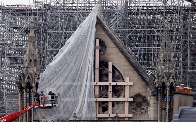 „Reuters“/„Scanpix“ nuotr./Paryžiuje darbininkai pradeda šalinti gaisro apgadintus pastolius Dievo Motinos katedroje