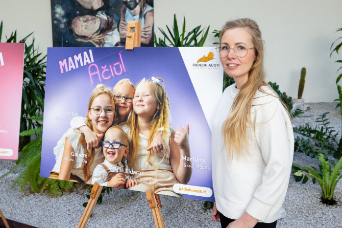 „Padedu augti“ nuotr./Gražina Stašionienė su plakatu, kuriame – jos vaikai