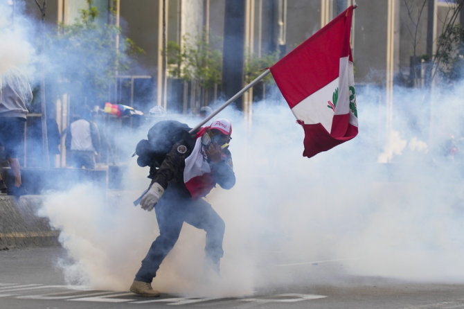 „AP“/„Scanpix“/Protestuotojas su Peru vėliava