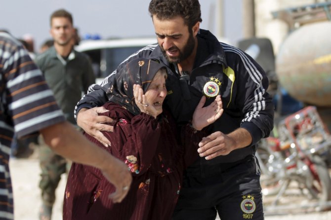„Reuters“/„Scanpix“ nuotr./Moteris, per bombardavimą netekusi savo artimųjų