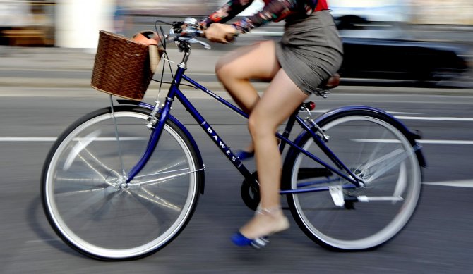 „Scanpix“/„PA Wire“/„Press Association Images“ nuotr./Mergina važiuoja dviračiu