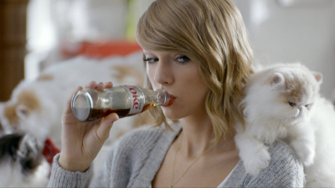 Vida Press nuotr./Taylor Swift ir jos katė Olivia Benson filmuojasi dietinės „Coca colos“ reklamai